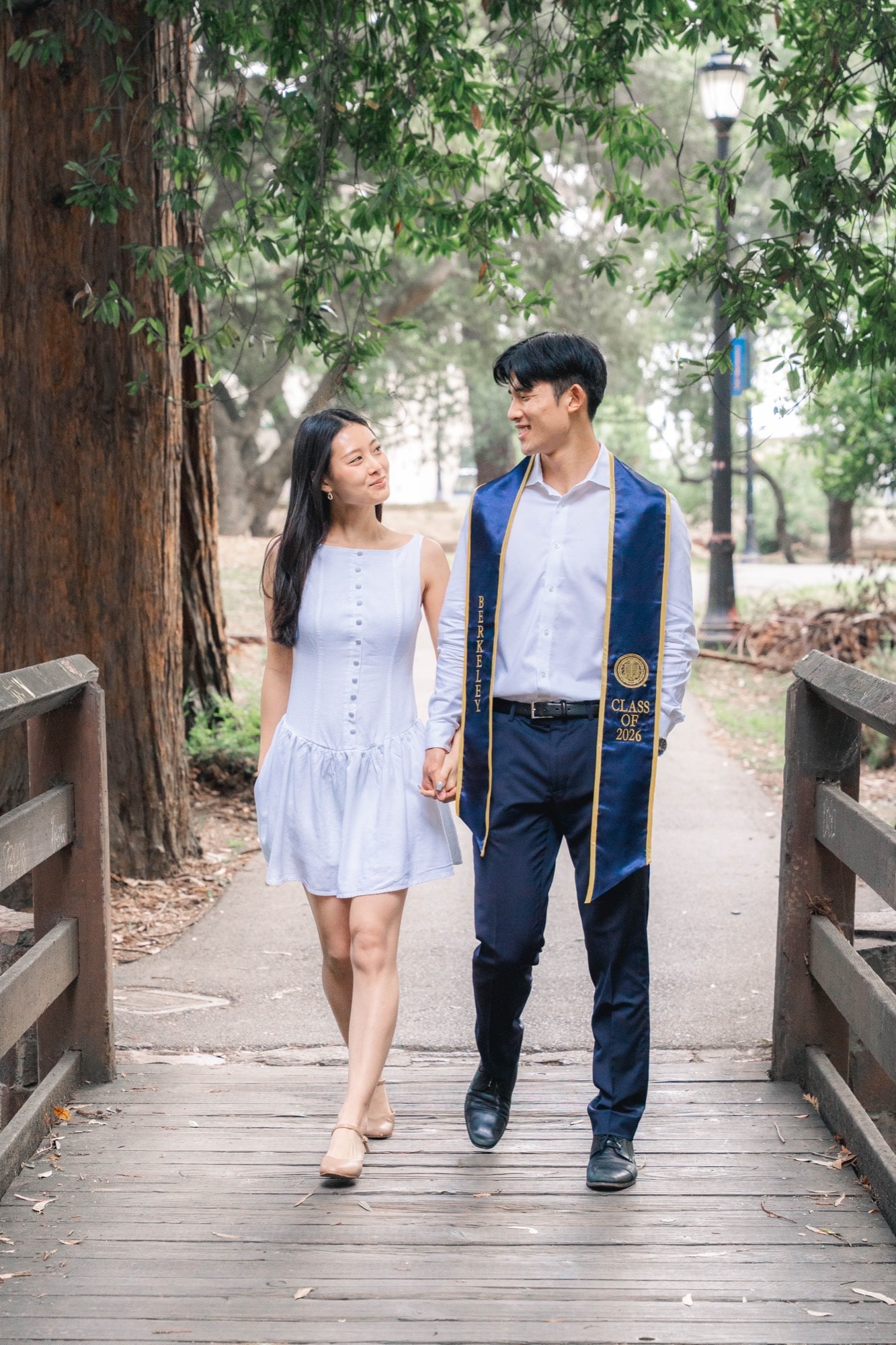 Couple walking hand in hand across a wooden footbridge