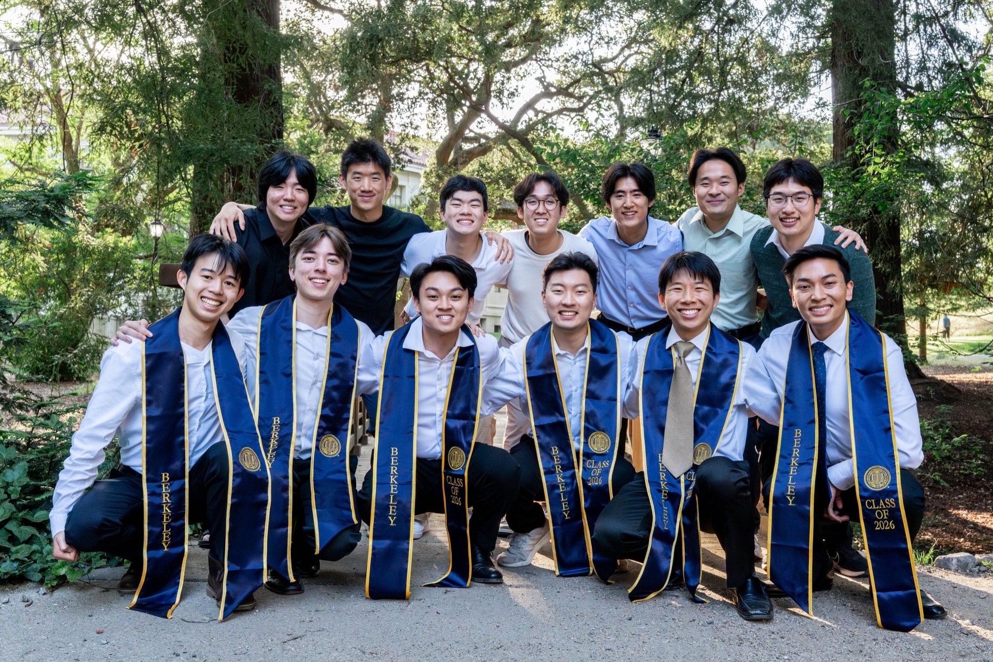 Group of graduates posed before a campus building